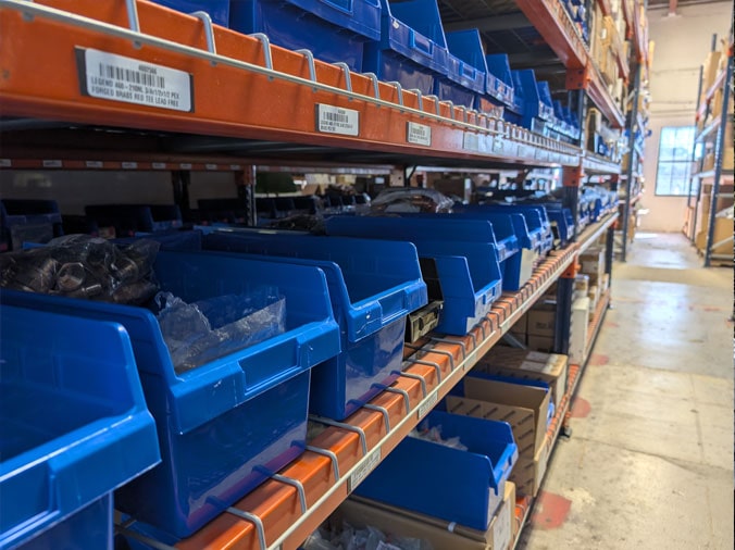 Plumbing parts in blue bins in the Hughes Supply Naples plumbing supply warehouse